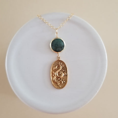 Gold snake pendant necklace with emerald gemstone, symbolizing transformation and elegance, perfect for statement jewelry lovers. Gift for women