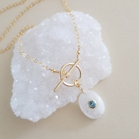 Handmade gold chain necklace with front toggle clasp, featuring a shimmering moonstone pendant and faceted blue topaz drop, elegant gemstone jewelry for everyday wear or special occasions.