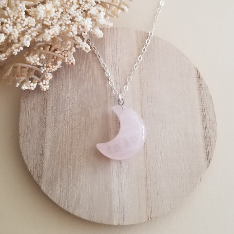 A delicate Rose Quartz Crescent Moon pendant necklace on a dainty gold chain, featuring soft pink tones and a feminine boho style