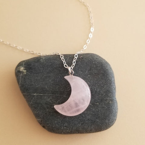 A delicate Rose Quartz Crescent Moon pendant necklace on a dainty gold chain, featuring soft pink tones and a feminine boho style