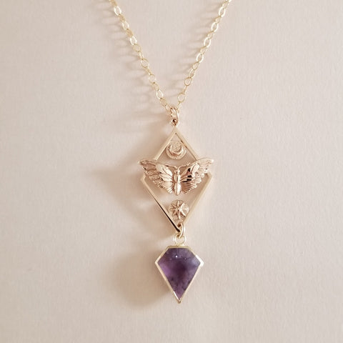 Necklace with geometric pendant and purple gemstone on a light background