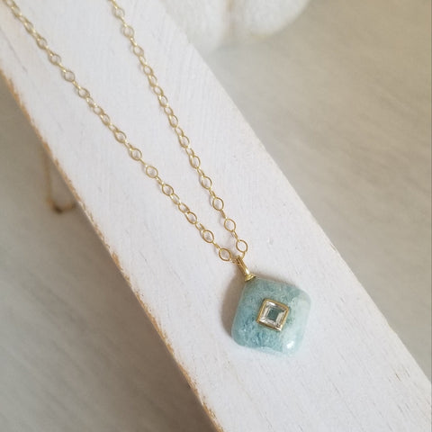 Delicate aquamarine pendant with white topaz inlay on a thin gold chain, dainty March birthstone necklace for women.