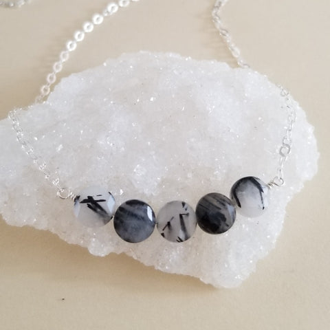 Minimalist necklace with a row of faceted black rutilated quartz stones on a dainty chain, elegant handmade crystal jewelry.