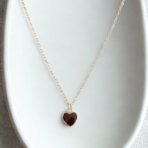 Necklace with a heart-shaped garnet pendant on a white background