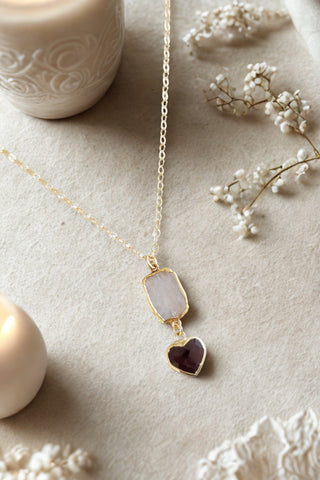 Handmade boho moonstone and garnet heart pendant necklace displayed on a gold filled chain.