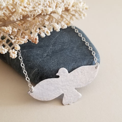 Hand-hammered bird pendant necklace featuring a soaring bird design on a dainty sterling silver chain.. Symbolic of freedom and grace, this handmade necklace makes a meaningful gift for her or a beautiful everyday accessory.