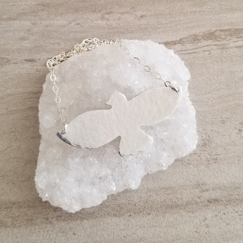 Hand-hammered bird pendant necklace featuring a soaring bird design on a dainty sterling silver chain.. Symbolic of freedom and grace, this handmade necklace makes a meaningful gift for her or a beautiful everyday accessory.