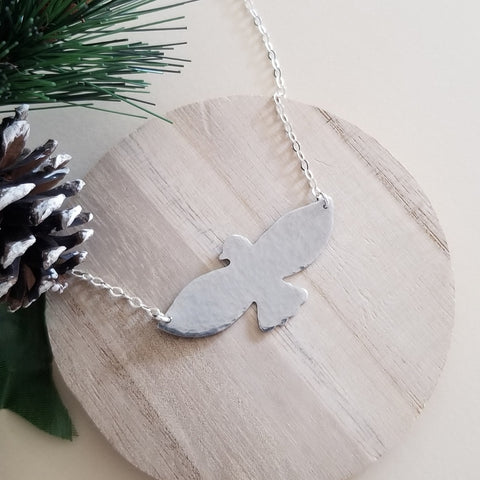 Hand-hammered bird pendant necklace featuring a soaring bird design on a dainty sterling silver chain.. Symbolic of freedom and grace, this handmade necklace makes a meaningful gift for her or a beautiful everyday accessory.