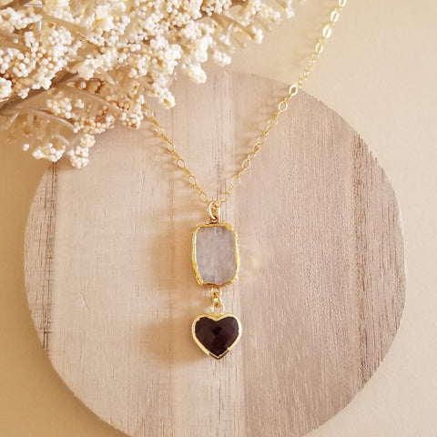 Handmade moonstone and garnet heart pendant necklace displayed on a gold filled chain. Gift for Her